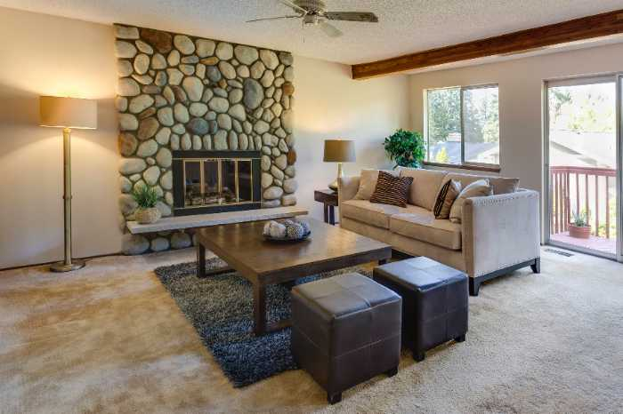 stone fireplace in living room with ottoman coffee table