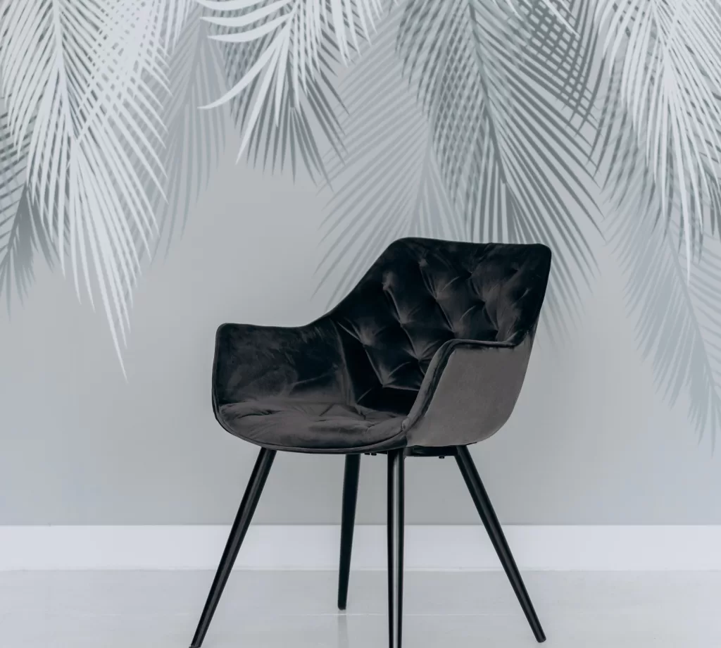 black velvet tufted chair with botanical wall decal